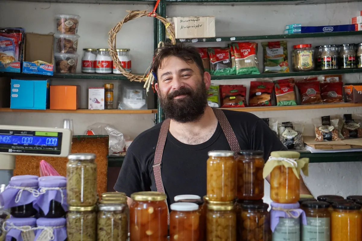 Comerciante atendendo no balcão do próprio estabelecimento